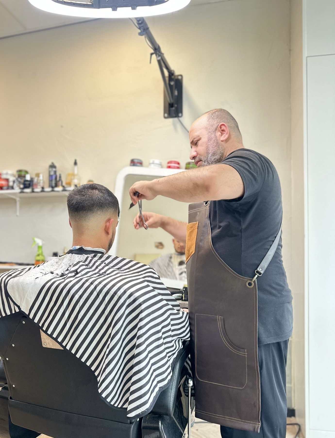 De barbier aan het werk in Barbershop Ziko